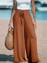 Charger l'image dans la galerie, Pantalon large style vacances pour femme : taille haute élastique avec cordon de serrage, coupe ample et droite, idéal pour la plage ou la détente.
