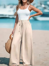 Charger l'image dans la galerie, Pantalon large style vacances pour femme : taille haute élastique avec cordon de serrage, coupe ample et droite, idéal pour la plage ou la détente.
